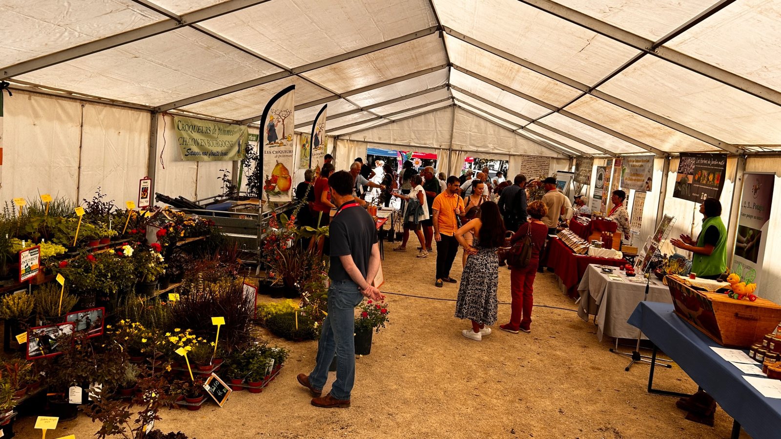 Visiteurs et stands sous le chapiteau de la foire